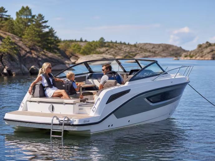 Familj i flytvästar kopplar av i en daycruiser i skärgården.